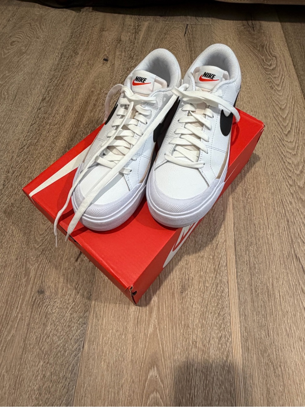 Nike White Low-Top Sneakers with Black Swoosh and Red Logo